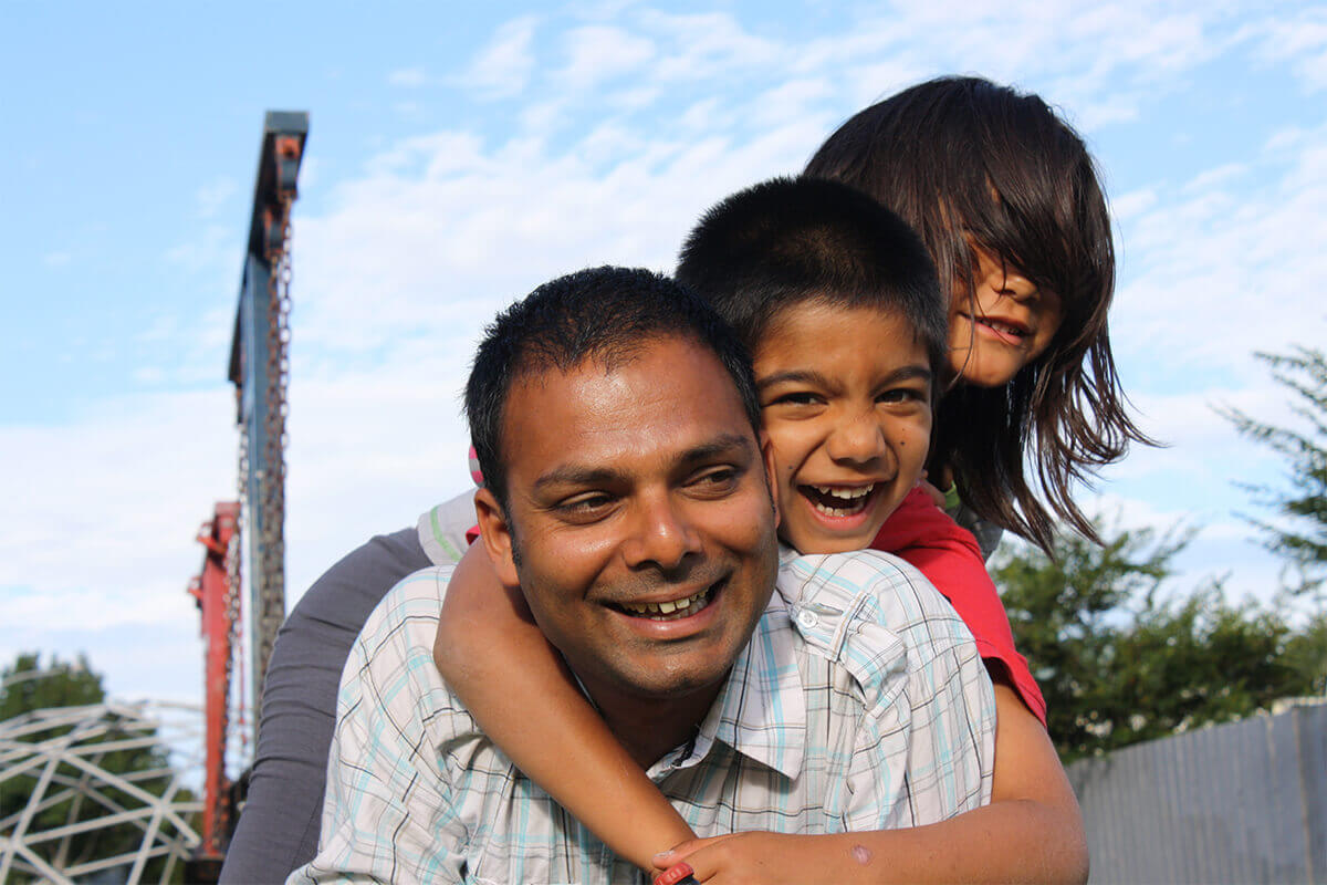 Debt free Father - Alpesh - plays with his two children in the park
