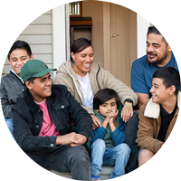 Family-laughing---Circle-v3 family sitting on the front step of their house smiling